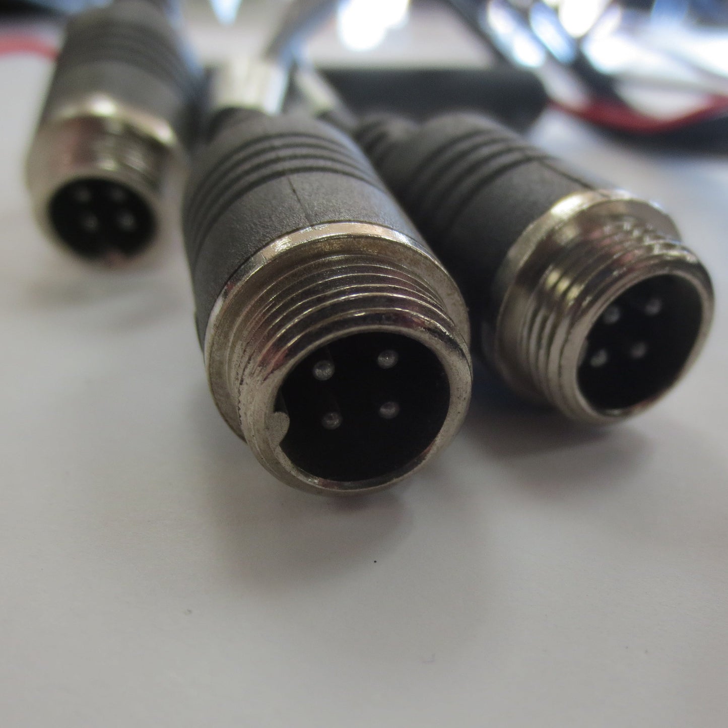 Close-up of three metal connectors on a white surface
