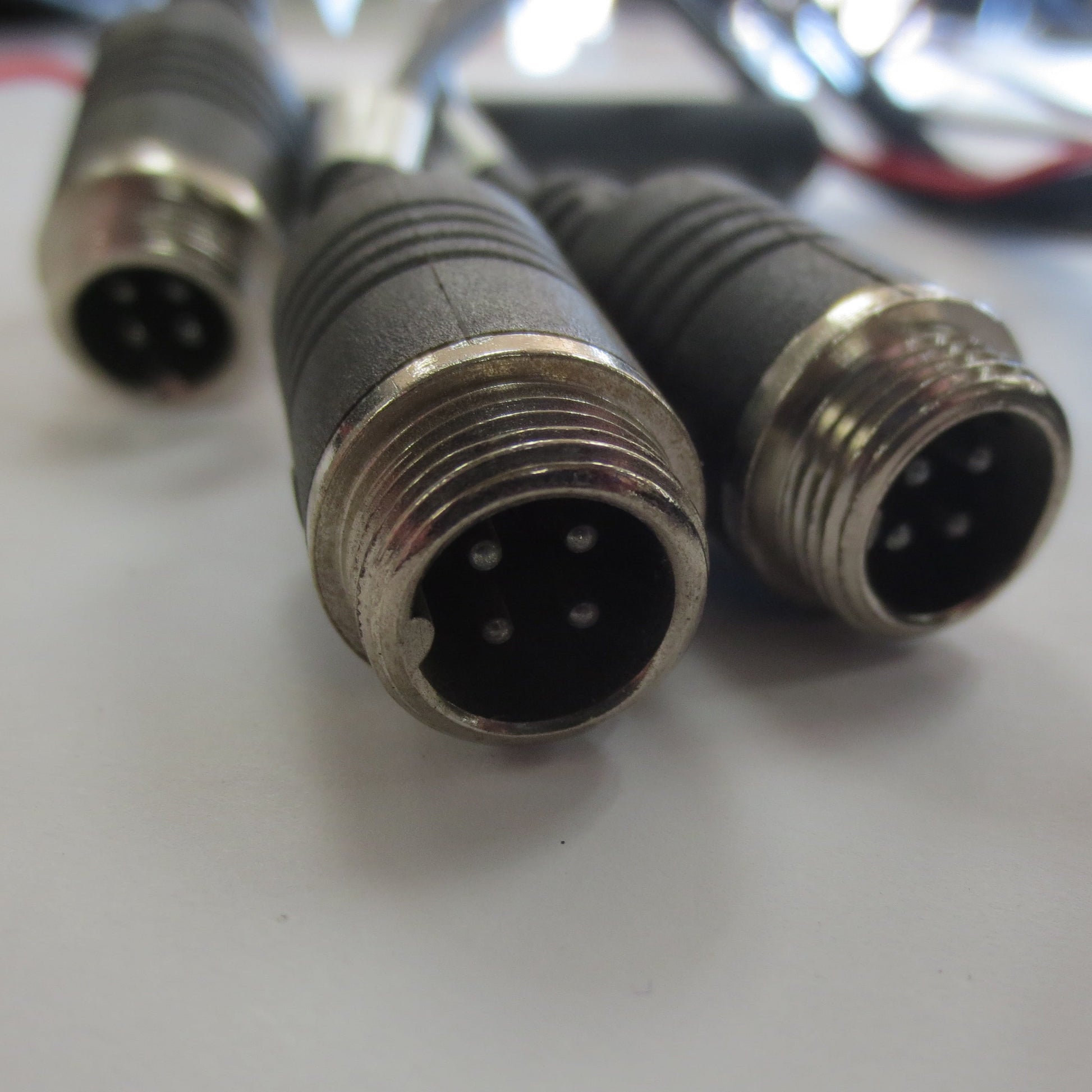 Close-up of three metal connectors on a white surface