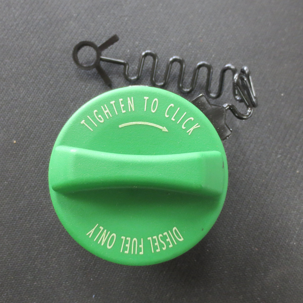 Green fuel cap with text 'Tighten to Click' and 'Diesle Fuel Only' on a black background