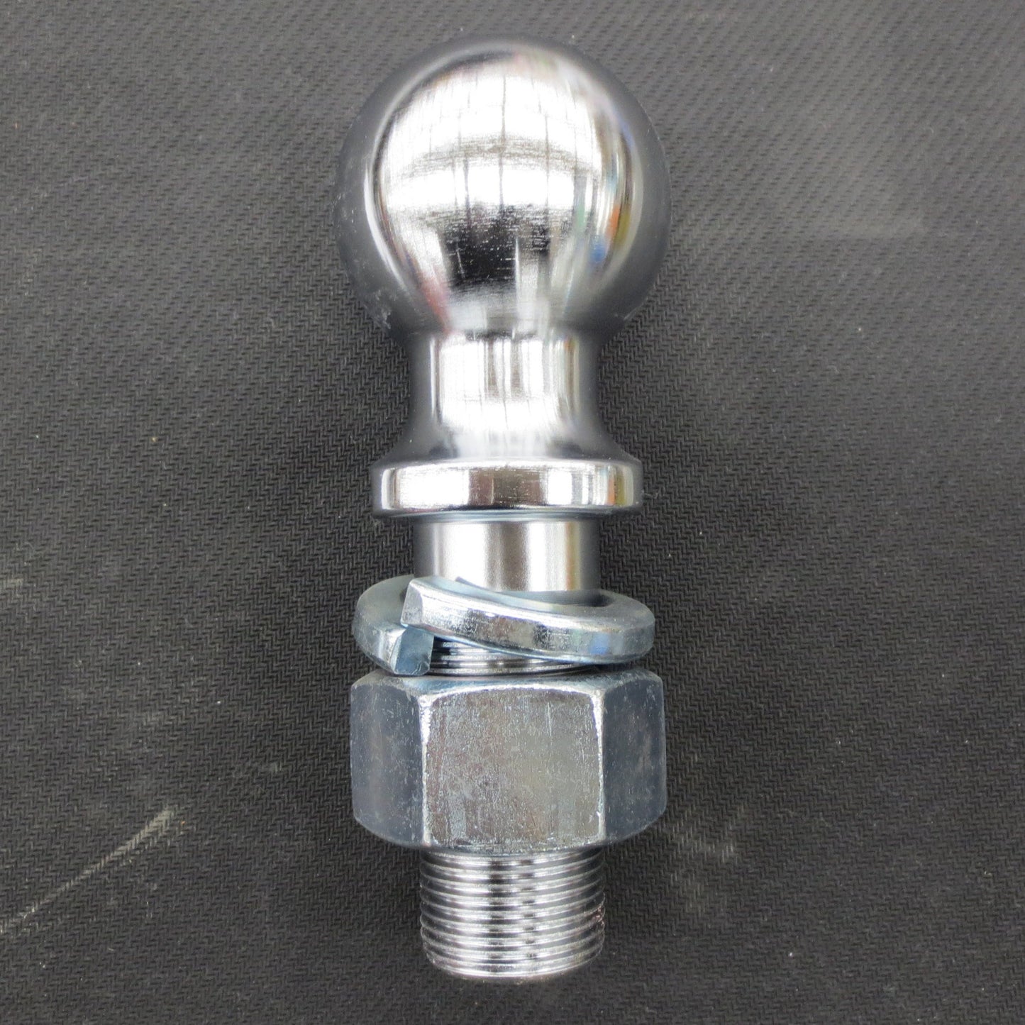 Metal trailer hitch ball on a gray background